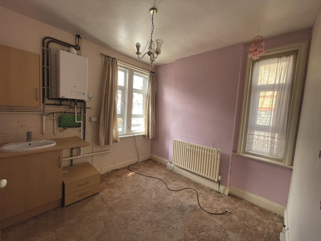 Lot: 144 - END-TERRACE PROPERTY ARRANGED AS THREE-BEDROOM HOUSE - Bedroom with hand basin and boiler